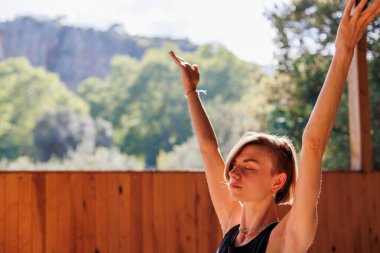 Sokakta esneme hareketleri yapan genç bir kadın. Sağlıklı bir yaşam tarzı. Spor giyimli güzel bir kız yoga yapıyor..