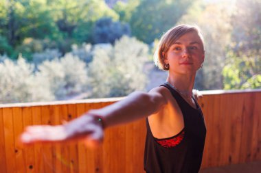 Sokakta esneme hareketleri yapan genç bir kadın. Sağlıklı bir yaşam tarzı. Spor giyimli güzel bir kız yoga yapıyor..