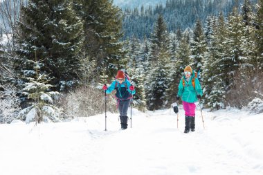İki kız kış dağlarında seyahat eder. kış yürüyüşü