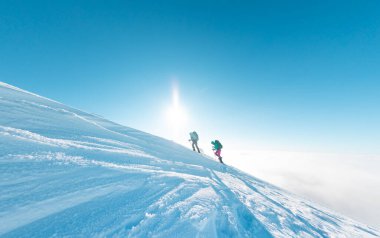 climbers climb the mountain. two girls in snowshoes walk in the snow. hiking in the mountains in winter.