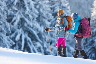 İki kadın kış yürüyüşünde karda yürür, iki kadın kışın dağlarda, yürüyüş ekipmanları, kar ayakkabıları