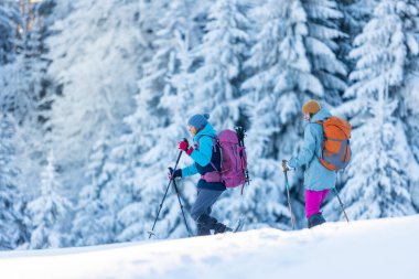 Kış dağları. Kar ayakkabılı ve sırt çantalı iki kişi yürüyüşe çıktı. Macera ve aşırı eğlence kavramı..