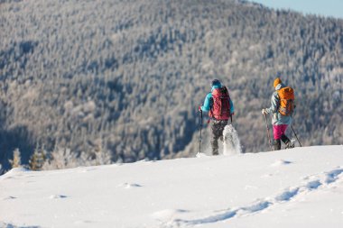 İki kız kış dağlarında seyahat eder. kış yürüyüşü