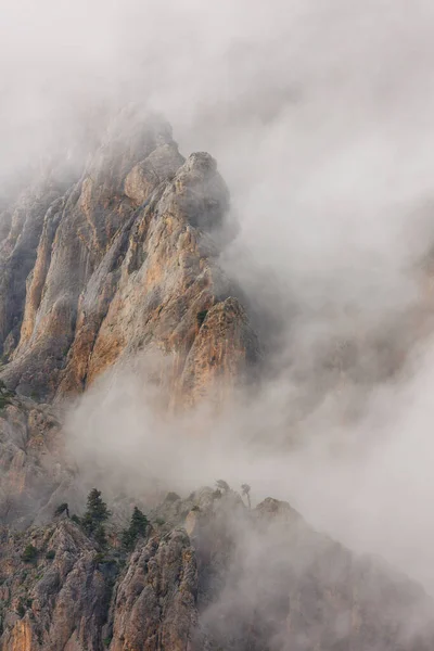 Mountains in the clouds. Mountain landscape. View of the mountain peak in the fog. Beautiful landscape with high cliffs. Dedegol. Turkey.