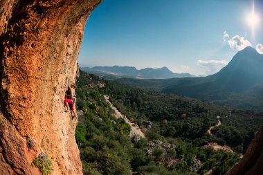 Girl climbs on the rock, rock climbing in Turkey, the sports girl is engaged in rock climbing. extreme sport