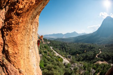 Girl climbs on the rock, rock climbing in Turkey, the sports girl is engaged in rock climbing. extreme sport