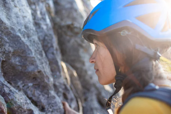 face of a rock climber girl in a blue helmet close-up. mountaineering and climbing. sport adventure concept.