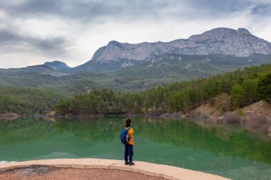 Sırt çantalı bir çocuk güzel bir dağ gölüne bakar. Sakin, huzurlu, düşünceli, mutlu ve özgür bir dağ gölünde. Çocuklarla Tatil