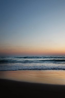 Yaz akşamından sonra deniz sahilinde yeni bir ay doğuyor. Güzel manzara.
