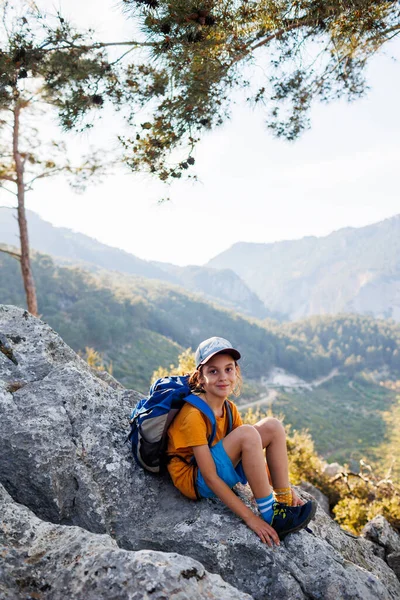 Traveling child. tourist with a backpack is resting on a mountain path. hiking and active healthy lifestyle. adventure holidays with children.