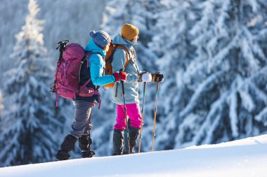 İki kadın kış yürüyüşünde karda yürür, iki kadın kışın dağlarda, yürüyüş ekipmanları, kar ayakkabıları