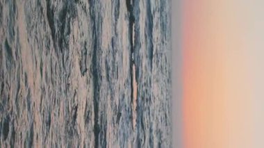 Dikey çekim. Dalgalar, su sıçramaları. Fırtına sonrası dramatik gökyüzü, destansı deniz manzarası. Fırtınalı bir havada yelken açmak. Doğa, turistik yerler. İsrail.