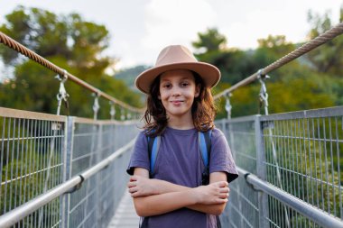 Kendine güvenen bir çocuğun portresi. Sokakta duran şapkalı bir çocuk. macera ve seyahat.