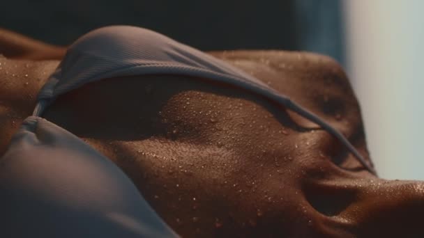 垂直ショット 水滴が日没時に日焼けした若い女性の体から流れ出る ビーチでのリラックス — ストック動画