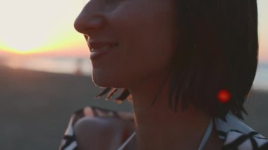 Plajda elinde havluyla bir kızın portresi. Gün batımında plajda havluya sarılmış bir kız. Denizde tatil.