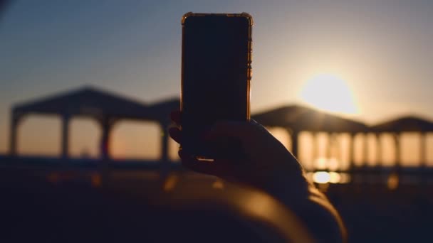 Жінка Знімає Відео Сонця Йде Над Горизонтом Моря Мобільному Телефоні — стокове відео