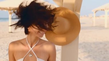 Denizde tatilin tadını çıkaran hoş bir kız. Kumsalda gülümseyen genç ve mutlu bir kadın. Rahatlama ve sağlık konsepti.