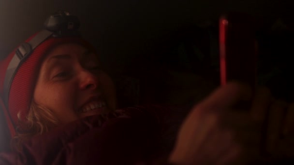 女孩躺在帐篷里 用手机 冬野营山里的寒假 — 图库视频影像