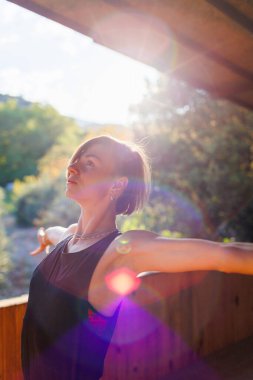 Güzel genç bir kadın sokakta yoga yapıyor. Formda bir kadın esneme egzersizleri yapıyor. Meditasyon ve rahatlama