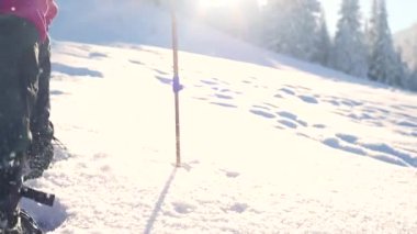 Dağcı karda kar ayakkabılarıyla yürür, kış yürüyüşü yapar, kışın dağlarda gezer, yürüyüş malzemesi taşır.