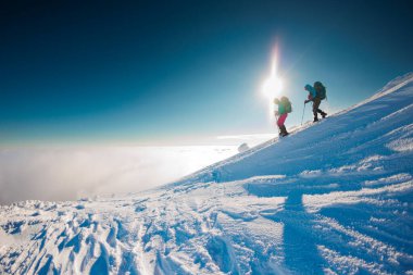 Dağcılar dağa tırmanır. Kış dağcılığı. Kar ayakkabılı iki kız karda yürür. Kışın dağlarda yürüyüş..