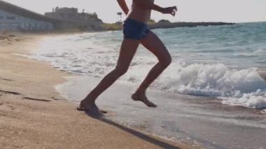 Mutlu bir çocuk denize koşar. Okyanus sahilinde bir çocuk oynuyor. Gün batımında bir çocuk dalgalara atlıyor. Çocuklu aileler için deniz tatili. Küçük bir çocuk tropik bir plaj boyunca koşar..