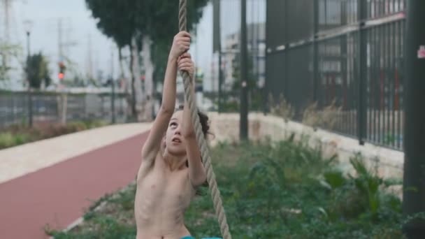 Pojkträning Idrottsplatsen Barnträning Ett Starkt Barn Klättrar Uppför Ett Rep — Stockvideo