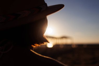 Gün batımında genç bir kızın portresi. Akşam deniz kenarında yürür.