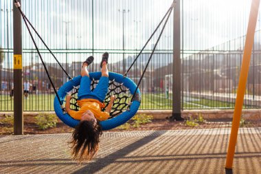Oğlan yaz günü salıncakta eğleniyor. Çocuk salıncağında mutlu bir çocuk. neşe ve eğlence.