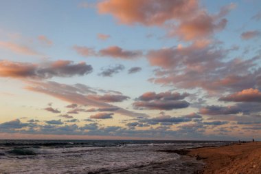 Dalgalar, su sıçramaları. Fırtınadan sonra gün batımında dramatik bir gökyüzü, destansı deniz manzarası. Fırtınalı bir havada yelken açmak. Hayfa seti, turistik yerler. İsrail. Hayfa.