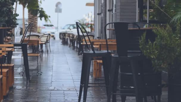 Pusty Mokry Drewniany Stół Krzesła Tarasie Ulicznej Kawiarni Podczas Deszczu — Wideo stockowe