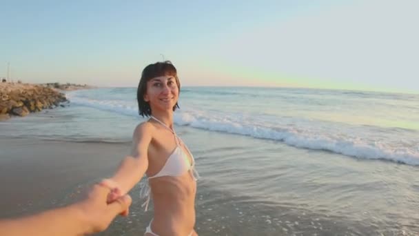 若いロマンチックなカップルは手を握るビーチで楽しんでいます 男の視点から撮影した 若い女の子と男が手を握る — ストック動画