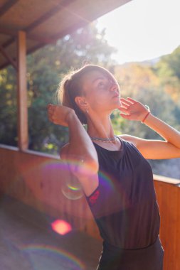 Güzel genç bir kadın sokakta yoga yapıyor. Formda bir kadın esneme egzersizleri yapıyor. Meditasyon ve rahatlama