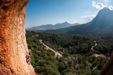 The girl climbs the rock. Climber trains on natural terrain. Extreme sport. Lessons on the street. A woman overcomes a difficult climbing route in Turkey. sports and adventure.