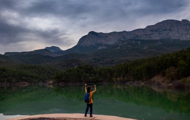 Mutlu çocuk dağdaki gölde seviniyor.