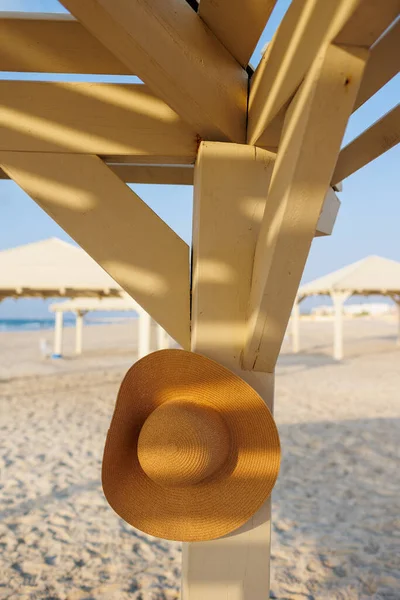 A broken hat hangs on a pole on the beach. relaxation on the beach.