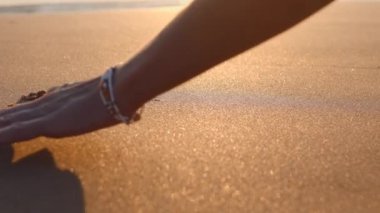 Sevgililer Günü. Kızlar ıslak sahil kumuna bir kalp işareti çizerler. Aşk ve tutku kavramı.