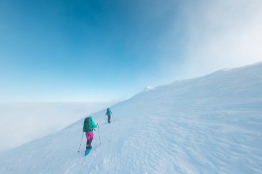 climbers climb the mountain. two girls in snowshoes walk in the snow. hiking in the mountains in winter.