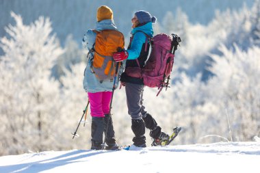 İki kadın kış yürüyüşünde karda yürür, iki kadın kışın dağlarda, yürüyüş ekipmanları, kar ayakkabıları