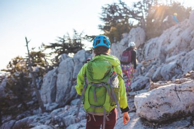 Dağcı kayalık tepe boyunca gider. Dağlara tırmanan bir kız. Macera konsepti ve dağlarda yürüyüş. Türkiye.