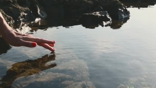 Kadının Eli Parmaklarıyla Suyun Yüzeyine Dokunarak Büyüleyici Dalgalanmalar Yaratıyor Sakin — Stok video