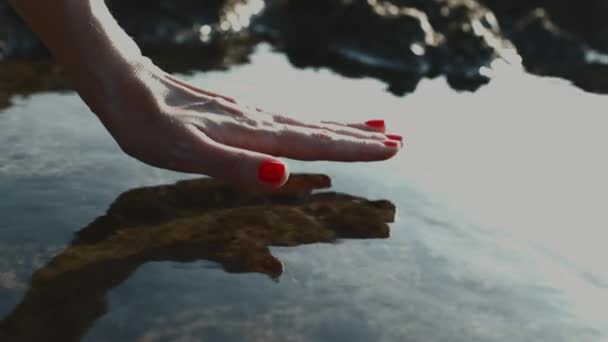 Tangan Seorang Wanita Menyentuh Permukaan Halus Air Menciptakan Riak Memikat — Stok Video
