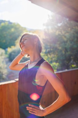 Güzel genç bir kadın sokakta yoga yapıyor. Formda bir kadın esneme egzersizleri yapıyor. Meditasyon ve rahatlama