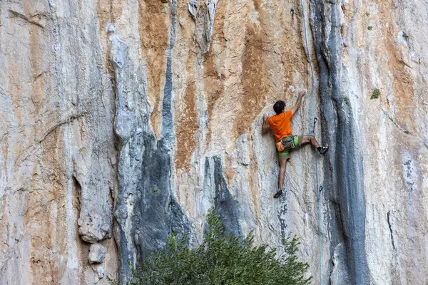 Extreme sport, man climbs a rock, a rock climber climbs a difficult route.