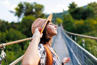 Mutlu kız seyahat eder. Şapkalı ve sırt çantalı genç bir kadın seyahat etmekten hoşlanıyor. Seyahat ve macera.