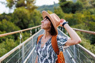 Mutlu kız seyahat eder. Şapkalı ve sırt çantalı genç bir kadın seyahat etmekten hoşlanıyor. Seyahat ve macera.