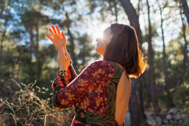 Denge, uyum ve sağlık kavramı. Doğayla baş başa bir kız. Bir kız ormanda ağaçların arasında dans edip şarkı söylüyor. Doğal manzaraların arasında genç ve güzel bir kız..