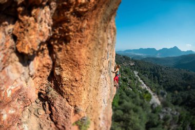 Girl climbs on the rock, rock climbing in Turkey, the sports girl is engaged in rock climbing. extreme sport