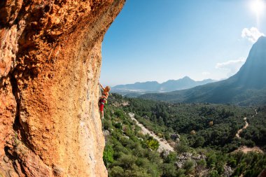 The girl climbs the rock. Climber trains on natural terrain. Extreme sport. Lessons on the street. A woman overcomes a difficult climbing route in Turkey. sports and adventure.