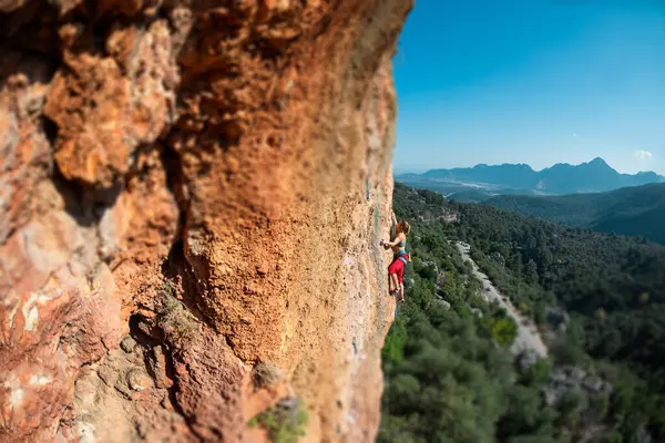 Girl climbs on the rock, rock climbing in Turkey, the sports girl is engaged in rock climbing. extreme sport